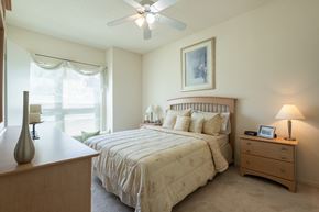 Overland Park apartment for rent - A comfortable sleeping space with soft lighting and plush carpeting.